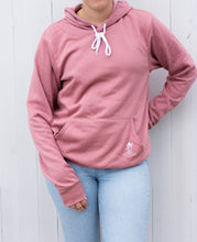 Load image into Gallery viewer, Model wearing pink sweatshirt with white angel logo 
