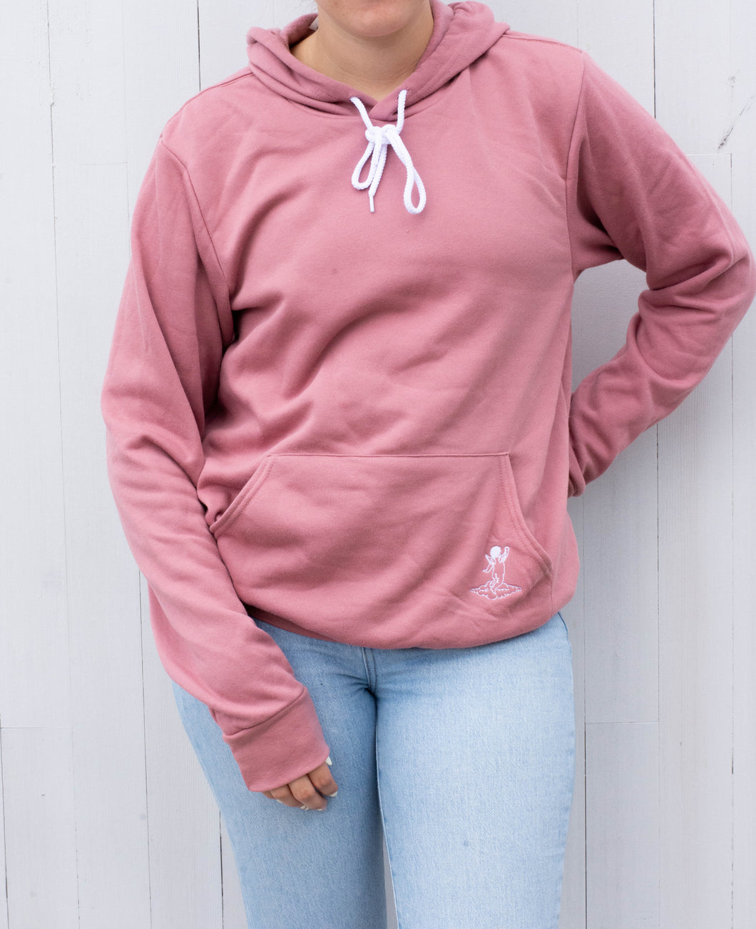 Model wearing pink sweatshirt with white angel logo 