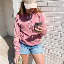 Load image into Gallery viewer, Model wearing a pink sweatshirt and holding a matcha latte 
