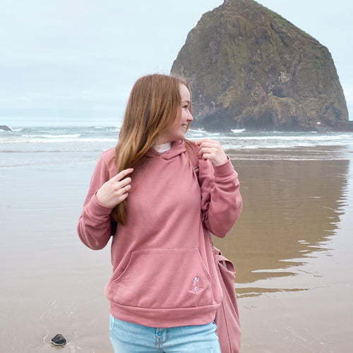 Model wearing pink sweatshirt on the beach 