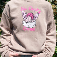 Load image into Gallery viewer, Tan crewneck sweatshirt with a cherub with pink hair on wings on a cloud. The words &#39;The Cheeky Cherub&#39; are written in hot pink cursive writing 
